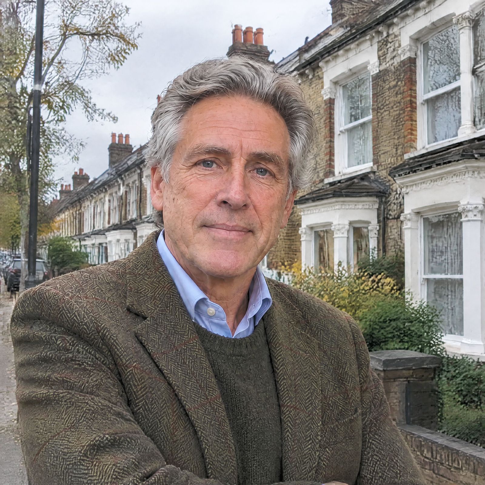 Peter Hallam outside a row of terrace houses